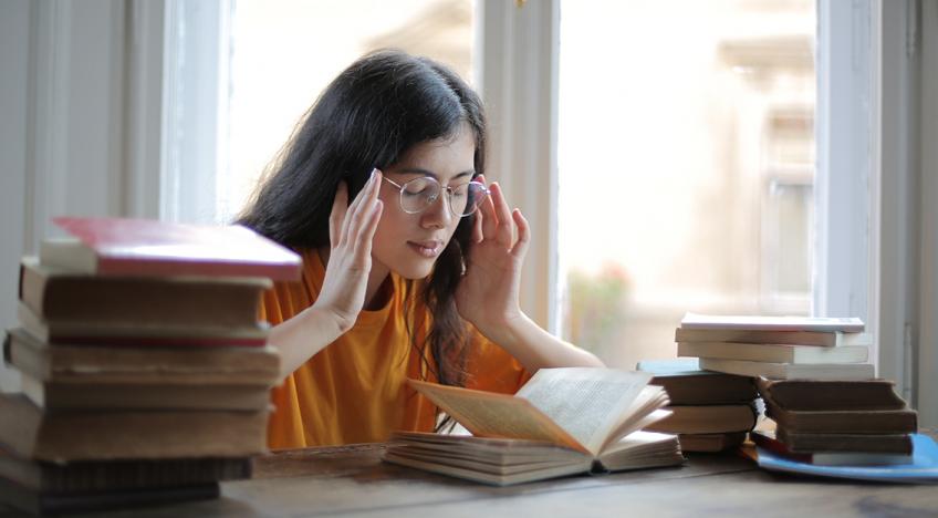 Vizsgadrukk stressz izguló diáklány a könyvei fölött